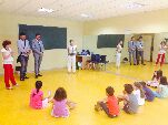 El alcalde y el concejal, junto a las monitoras, escuchan a los niños que participan en los talleres